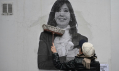 Une partisane de Cristina Kirchner colle un portrait de l'ex-présidente argentine sur un mur de la résidence de celle-ci, le 17 juin 2025 à Buenos Aires ( AFP / Luis ROBAYO )