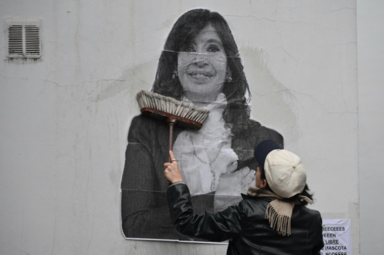 Une partisane de Cristina Kirchner colle un portrait de l'ex-présidente argentine sur un mur de la résidence de celle-ci, le 17 juin 2025 à Buenos Aires ( AFP / Luis ROBAYO )