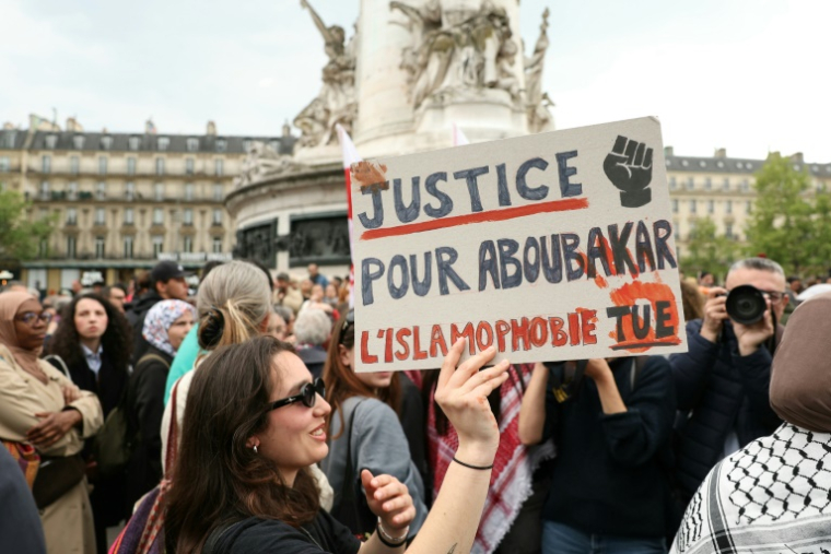 Un manifestant tient une pancarte lors d'un rassemblement en hommage à Aboubakar, le fidèle tué dans une mosquée à La Grand-Combe, et contre l'islamophobie, Place de la République à Paris le 27 avril 2025 ( AFP / Alain JOCARD )