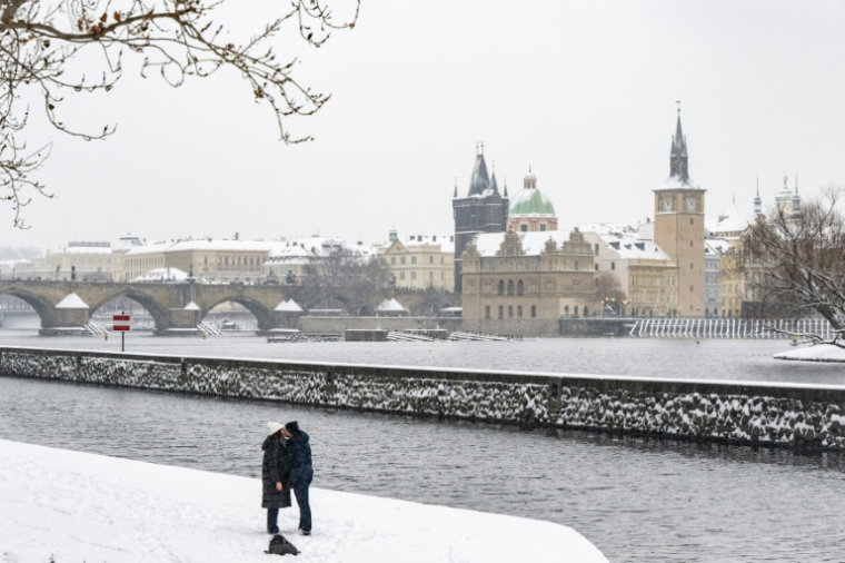 Un homme et une femme s'embrassent au bord de la rivière Vltava après la chute de la neige, le 9 janvier 2026 à Prague, en République tchèque ( AFP / Michal Cizek )