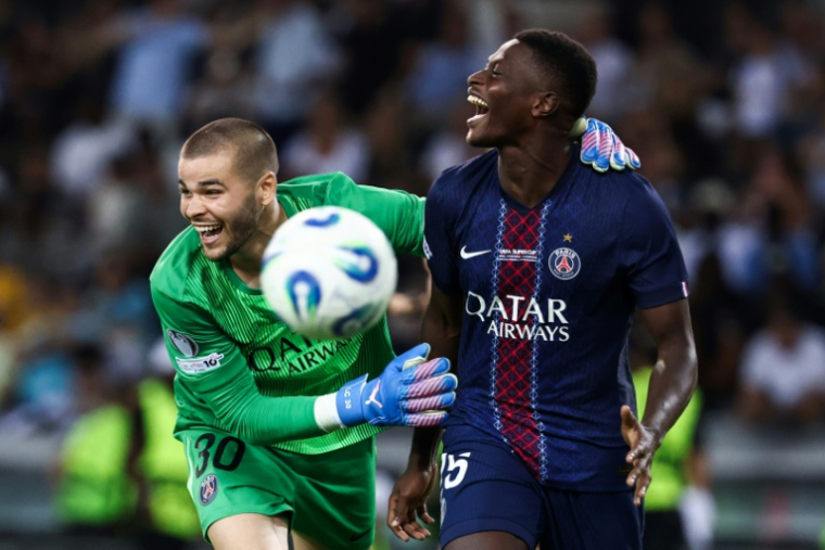 Le défenseur portugais du Paris SG Nuno Mendes (droite) est félicité par le gardien Lucas Chevalier après avoir inscrit le tir au but de la victoire en Supercoupe d'Europe contre Tottenham le 13 août 2025 à Udine (Italie) ( AFP / FRANCK FIFE )