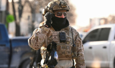 Un agent de la police aux frontières américaine devant des manifestants à Minneapolis, près du lieu où des agents fédéraux ont tué un homme par balle, le 24 janvier 2026 ( AFP / ROBERTO SCHMIDT )