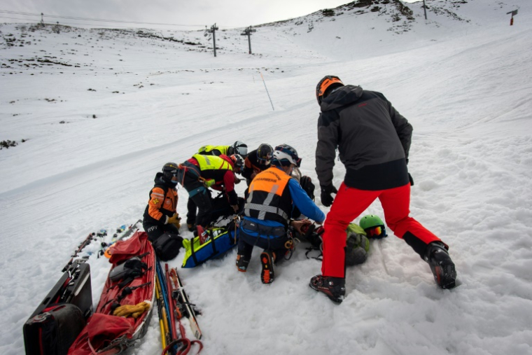 Des gendarmes du Peloton de Gendarmerie de Haute Montagne (PGHM) et un urgentiste du CHU de Tarbes prennent en charge une personne blessée sur une piste de ski à Luz Ardiden dans les Hautes Pyrénées, le 21 février 2025 ( AFP / Matthieu RONDEL )
