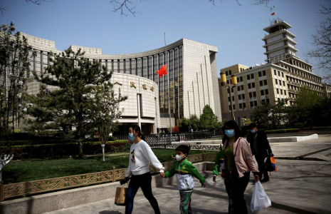Photo d'archives de personnes passant devant le siège de la banque centrale chinoise à Pékin