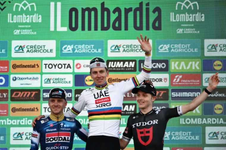 Tadej Pogacar entouré de Remco Evenepoel (G) et de Michael Storer (D) sur le podium du Tour de Lombardie, le 11 octobre 2025 à Bergame ( AFP / Marco BERTORELLO )