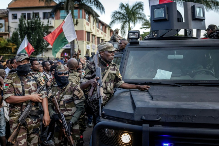 Des soldats malgaches en véhicules blindés sont entourés de manifestants saluant leur arrivée à l'hôtel de ville d'Antananarivo, le 11 octobre 2025 ( AFP / Luis TATO )