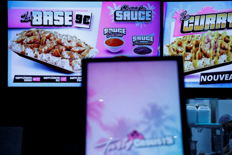 Un écran affiche les options de menu dans un restaurant de restauration rapide Tasty Crousty, le 18 février 2026 à Paris ( AFP / Charlotte SIEMON )