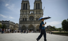 Un touriste se protège du soleil devant la cathédrale Notre-Dame de Paris, le 28 mai 2026 ( AFP / Simon WOHLFAHRT )