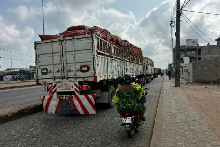 Une file de camions dans une rue de Cotonou après que des militaires ont annoncé à la télévision publique du Bénin avoir "démis de ses fonctions" le président Patrice Talon, le 7 décembre 2025 ( AFP / - )