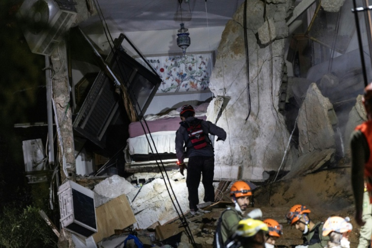Opérations de secours dans un immeuble de Haïfa, dans le nord d'Israël, détruit par une frappe iranienne le 5 avril 2026 ( AFP / Ilia YEFIMOVICH )