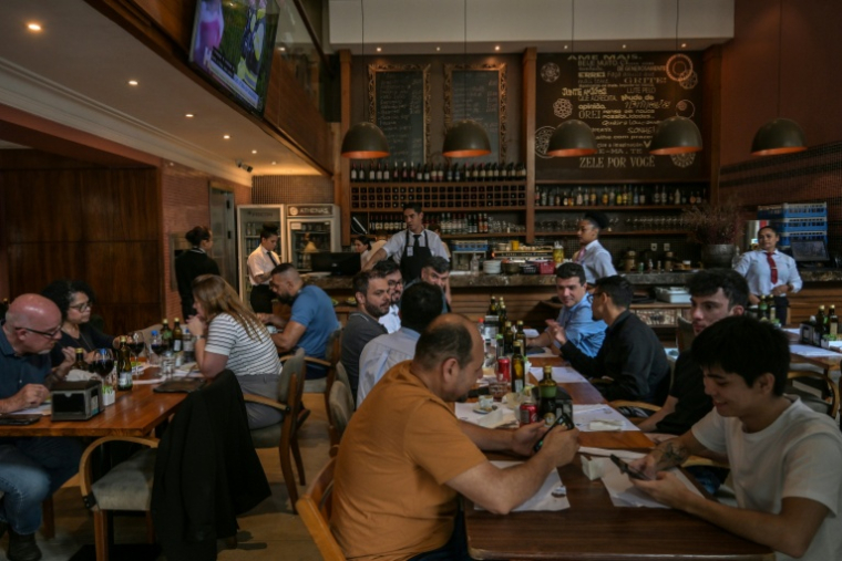 Des personnes déjeunent dans un restaurant à Sao Paulo, le 3 octobre 2025 au Brésil ( AFP / Nelson ALMEIDA )