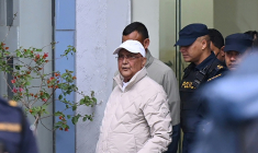 L'ancien Premier ministre KP Sharma Oli (c) escorté par la police lors de son transfert de la station de police du district de Katmandou à l'hôpital, le 28 mars 2026 au Népal ( AFP / Prakash Mathema )