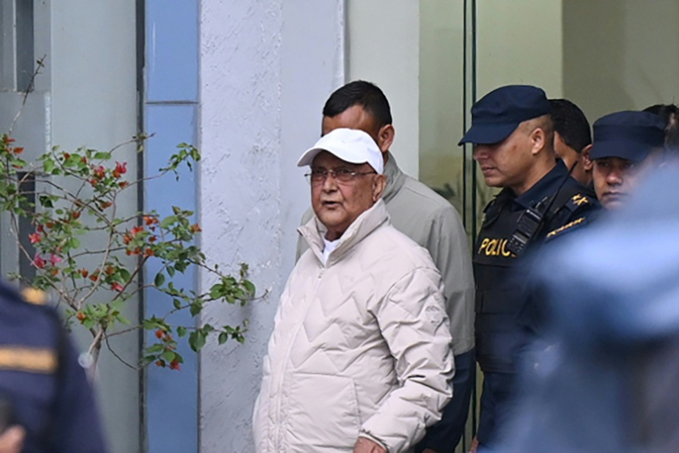 L'ancien Premier ministre KP Sharma Oli (c) escorté par la police lors de son transfert de la station de police du district de Katmandou à l'hôpital, le 28 mars 2026 au Népal ( AFP / Prakash Mathema )