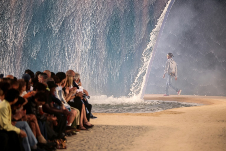 Le créateur Pharrell Williams lors du défilé Louis Vuitton à Paris le 23 juin 2026, avec la vague d'eau polémique en pleine canicule ( AFP / SIMON WOHLFAHRT )