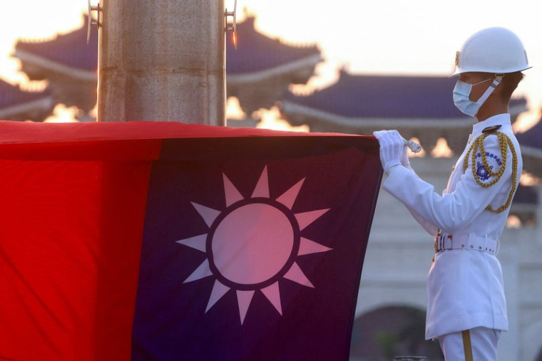 Photo d'archives: Les gardes d'honneur abaissent le drapeau de Taïwan pendant les heures de coucher du soleil sur la place de la Liberté à Taipei