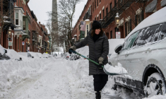 Une personne déneige la route à Boston, le 26 janvier 2026 ( AFP / Joseph Prezioso )
