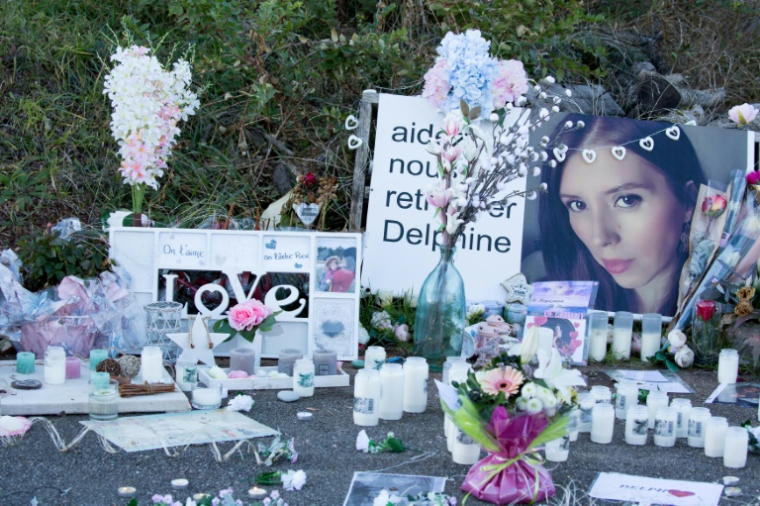 Des bougies et des fleurs déposées devant la maison de Delphine Jubillar à Cagnac-les-Mines (Tarn) lors d'une marche blanche un an après sa disparition, le 19 décembre 2021 ( AFP / FRED SCHEIBER )
