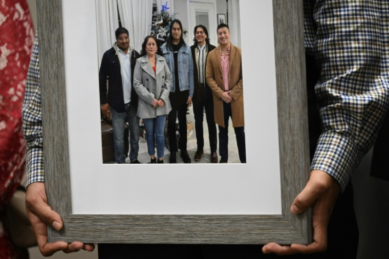 Ronaldo Salgado, fils de Lorenzo Salgado, tient un portrait de son père aux côtés de sa famille lors d'une conférence de presse à Houston (Texas), le 8 juillet 2026 ( AFP / RONALDO SCHEMIDT )