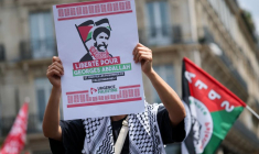 Une personne tenant une pancarte sur laquelle on peut lire "Liberté pour Georges Abdallah et pour tous les prisonniers palestiniens" à une manifestation en soutien aux Palestiniens de Gaza