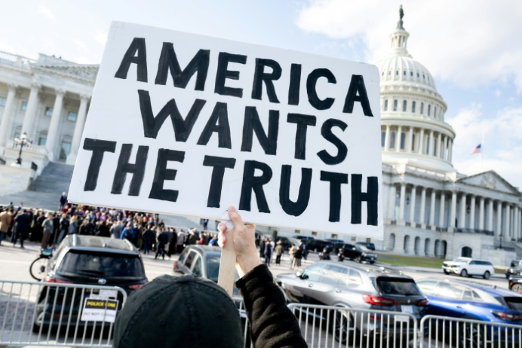 Un manifestant tient une pancarte "l'Amérique veut la vérité", demandant la publication des documents liés à l'affaire Epstein, devant le Capitole de Washington, siège du Congrès américain, le 12 novembre 2025 ( AFP / SAUL LOEB )