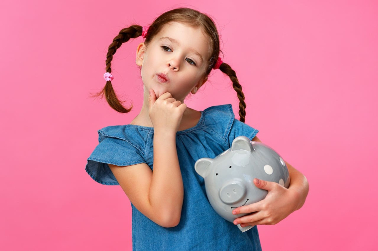 (Crédits photo : Adobe Stock - Fillette réfléchissant à l'argent avec sa tirelire)