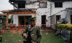 Un combattant du groupe armé M23 devant une résidence endommagée par une frappe de drone, à Goma, dans l'est de la République démocratique du Congo (RDC), le 11 mars 2026 ( AFP / Jospin Mwisha )
