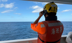 Cette photo fournie le 29 décembre 2025 par les garde-côtes taïwanais montre un agent observant un navire chinois, naviguant à  23 milles marins au nord-ouest de l'îlot Pengjia, au nord de Taïwan ( TAIWAN COAST GUARD / Handout )