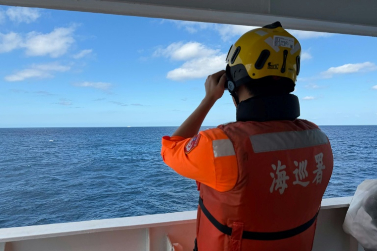 Cette photo fournie le 29 décembre 2025 par les garde-côtes taïwanais montre un agent observant un navire chinois, naviguant à  23 milles marins au nord-ouest de l'îlot Pengjia, au nord de Taïwan ( TAIWAN COAST GUARD / Handout )