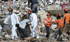 Des secouristes transportent un sac mortuaire à travers les décombres d’un immeuble effondré à Caraballeda, au Venezuela, le 17 juillet 2026, après les séismes du 24 juin. ( AFP / Juan BARRETO )