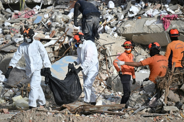 Des secouristes transportent un sac mortuaire à travers les décombres d’un immeuble effondré à Caraballeda, au Venezuela, le 17 juillet 2026, après les séismes du 24 juin. ( AFP / Juan BARRETO )