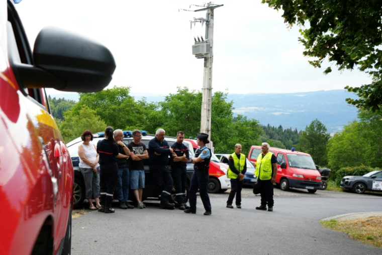 Des pompiers et un gendarme près des lieux où des spectateurs sont morts après avoir été heurtés par une voiture qui a quitté la route lors d'un rallye automobile à Saint-Just, dans le Puy-de-Dôme, le 26 juillet 2025 ( AFP / Sylvain Thizy )