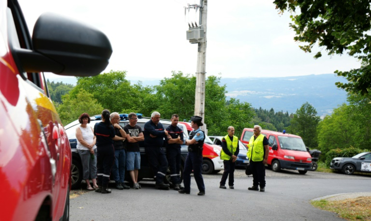 Des pompiers et un gendarme près des lieux où des spectateurs sont morts après avoir été heurtés par une voiture qui a quitté la route lors d'un rallye automobile à Saint-Just, dans le Puy-de-Dôme, le 26 juillet 2025 ( AFP / Sylvain Thizy )