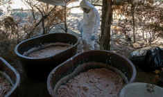 Un expert de l’armée mexicaine près de conteneurs contenant de la pâte de méthamphétamine dans un laboratoire clandestin près de La Rumorosa, au Mexique, le 28 août 2018  ( AFP / Guillermo Arias )