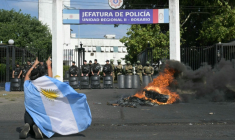 Une manifestante proteste, enveloppée du drapeau argentin, à Rosario, Argentine, le 11 février 2026 ( AFP / Juan Mabromata )