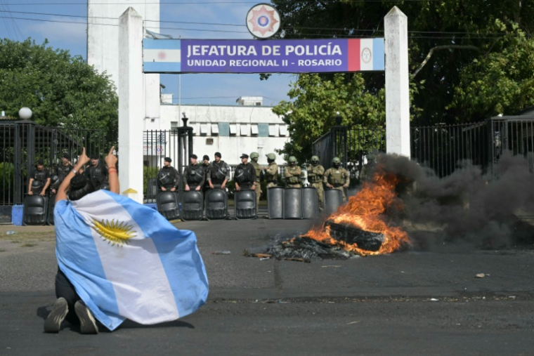 Une manifestante proteste, enveloppée du drapeau argentin, à Rosario, Argentine, le 11 février 2026 ( AFP / Juan Mabromata )