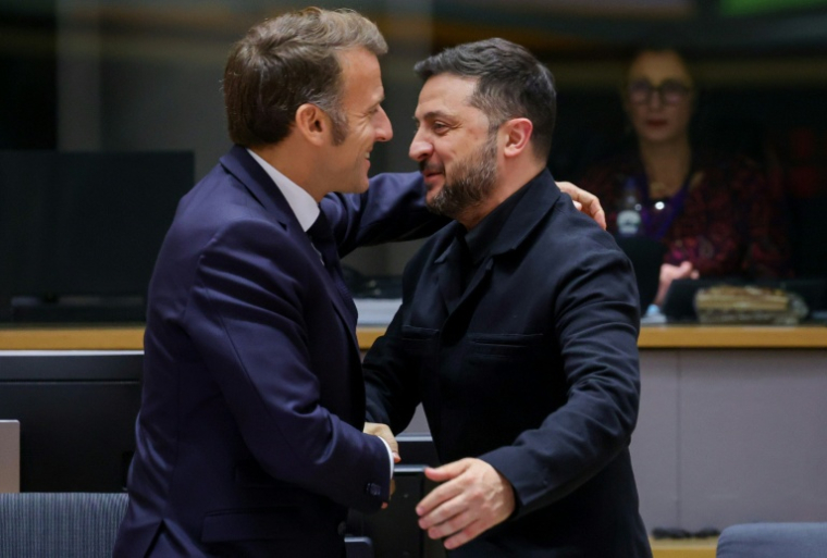 Le président ukrainien Volodymyr Zelensky (d) est accueilli par le président français Emmanuel Macron lors d'une réunion du Conseil européen qui rassemble les 27 dirigeants de l'UE, à Bruxelles, le 23 octobre 2025 ( POOL / Yves Herman )