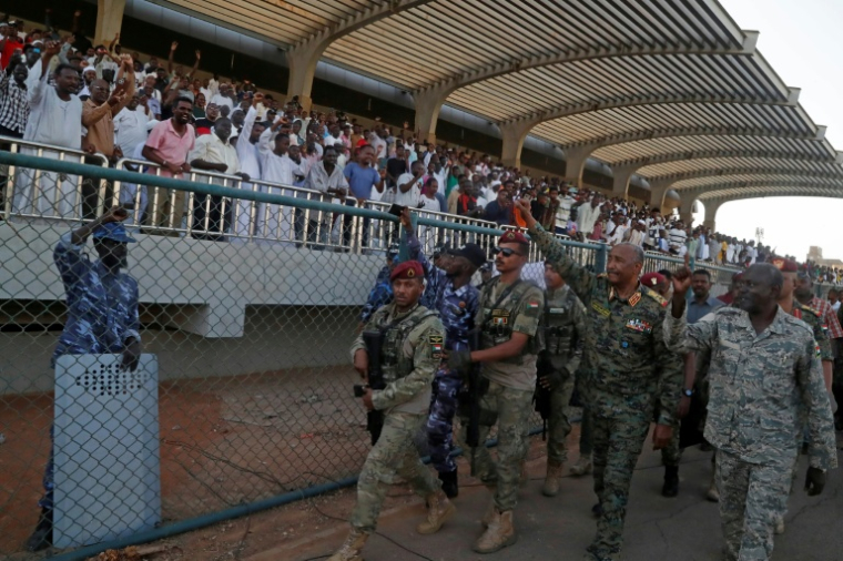 Le chef de l'armée et dirigeant de facto du pays, Abdel Fattah al-Burhane, salue les spectateurs après avoir assisté au match d'ouverture de la première ligue, le 15 mai 2026 au stade Kober à Khartoum ( AFP / Ebrahim Hamid )