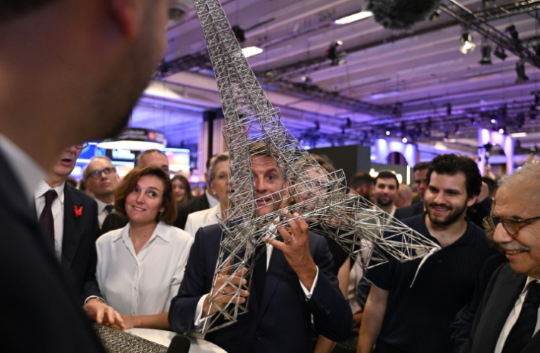 Emmanuel Macron tient une réplique de la tour Eiffel, au salon Vivatech, à Paris, le 18 juin 2026 ( POOL / Emma Da Silva )
