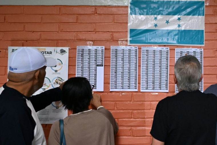 Des électeurs consultent les listes électorales dans un bureau de vote à Tegucigalpa, au Honduras, le 30 novembre 2025 ( AFP / MARVIN RECINOS )
