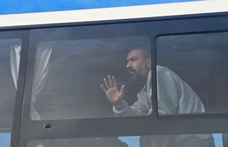 Un prisonnier palestinien libéré par Israël regarde par la fenêtre d'un bus