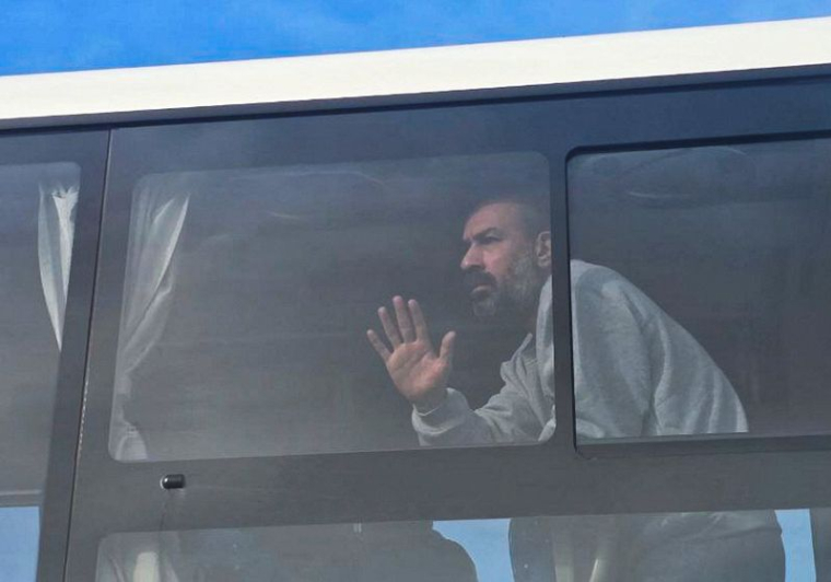 Un prisonnier palestinien libéré par Israël regarde par la fenêtre d'un bus
