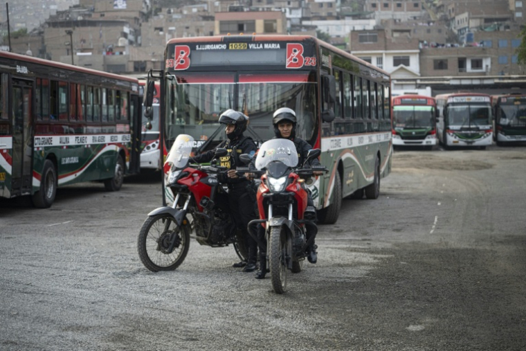 Des policiers devant des bus au dépôt dans le district populaire de San Juan de Lurigancho, le 8 avril 2026 à Lima ( AFP / ERNESTO BENAVIDES )
