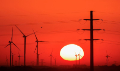 Des éoliens et des pylônes électriques sont photographiés au lever du soleil
