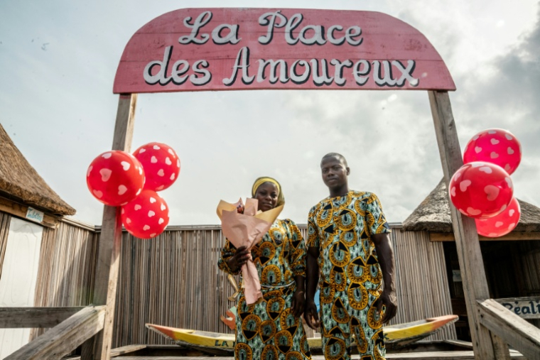Un couple fête la Saint-Valentin sur la Place des Amoueux dans la ville lacustre de Ganvié, le 10 février 2026 au Bénin ( AFP / Yanick Folly )