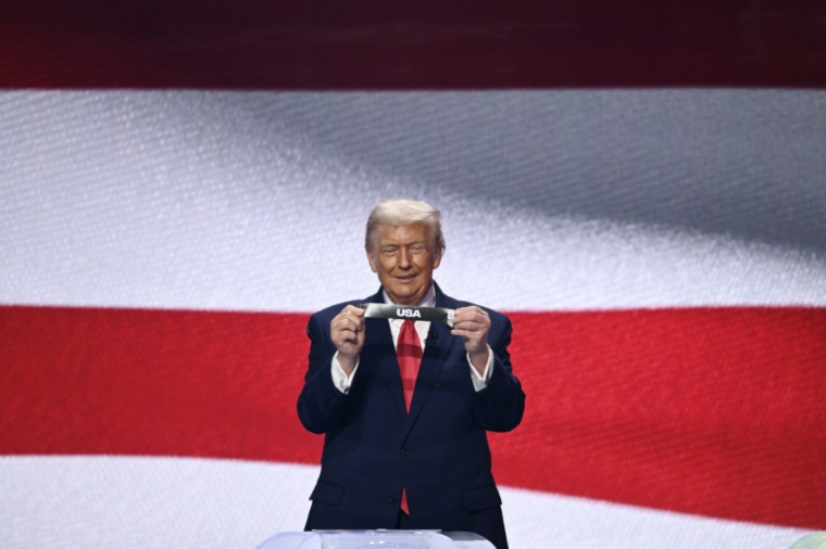 Le président américain, Donald Trump, montre un papier avec le nom des Etats-Unis lors du tirage au sort de la Coupe monde 2026 de football, le 5 décembre 2025 au Kennedy Center à Washington ( AFP / Brendan SMIALOWSKI )