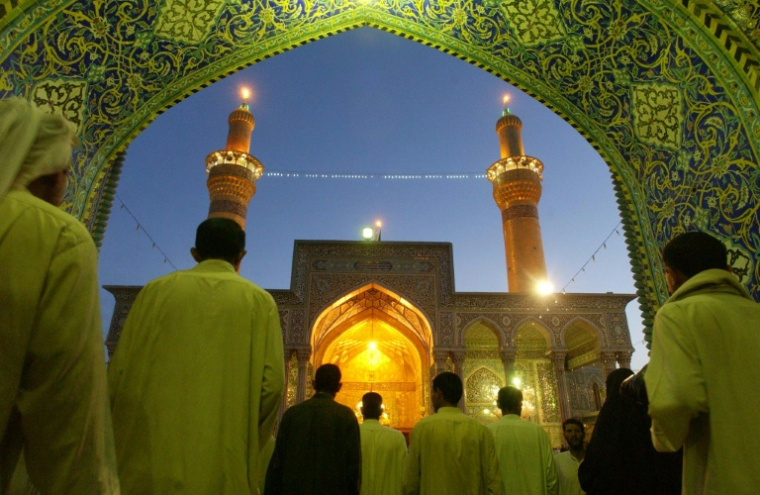 Des Irakiens chiites à l'entrée du sanctuaire de l'imam Hussein dans la ville sainte irakienne de Kerbala, le 23 avril 2003 ( AFP / ROMEO GACAD )