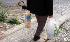 Une retraitée transporte un sac en plastique contenant des provisions et du pain tranché