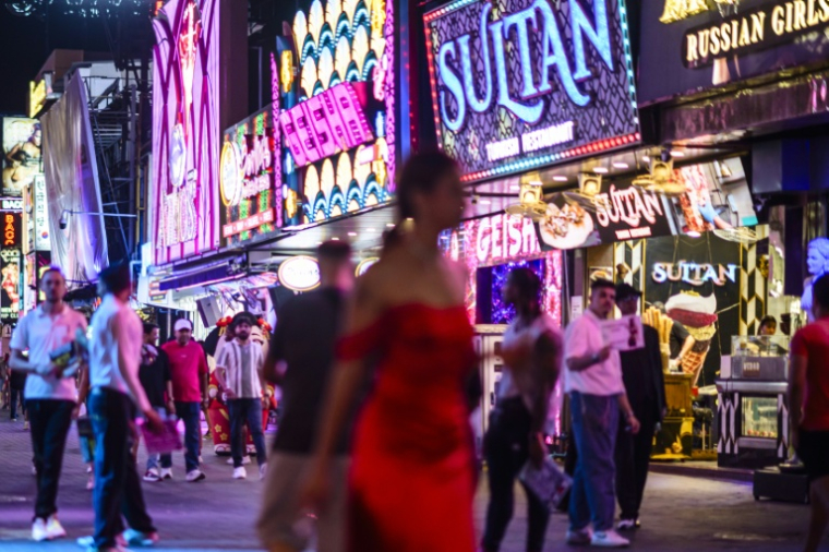 Des passants longent les bars et les clubs de Walking Street à Pattaya le 3 juillet 2026 ( AFP / ANTHONY WALLACE )