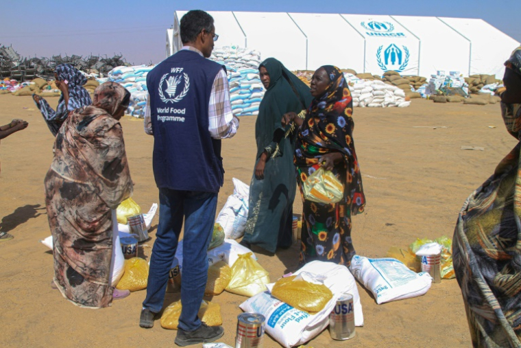 Distribution d'aide humanitaire au camp de déplacés d'Al-Afad, situé dans la ville d'Al-Dabba, au nord du Soudan, le 25 novembre 2025Sudanese women who fled El-Fasher receive humanitarian aid at the Al-Afad camp for displaced people in the town of Al-Dabba, northern Sudan, on November 25, 2025.  Sudan's army said on November 25 it had repelled a Rapid Support Forces attack on a strategic city in southern Kordofan, a day after the RSF declared a unilateral three-month ceasefire. In a statement, the military, which has been at war with the RSF since April 2023, said its troops had "pushed back an assault" on an infantry base in the town of Babanusa. ( AFP / Ebrahim HAMID )