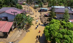 Cette photo aérienne montre des villageois pataugeant dans la coulée de boue pour trouver un abri après les crues soudaines du village de Tukka, dans le district de Tapanuli central, province de Sumatra du Nord, le 3 décembre 2025 ( AFP / YT Hariono )